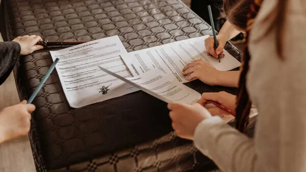 Des enfants participent à des ateliers magie de Sebastien Pieta et écrivent leur nom sur les règles d'or de la magie