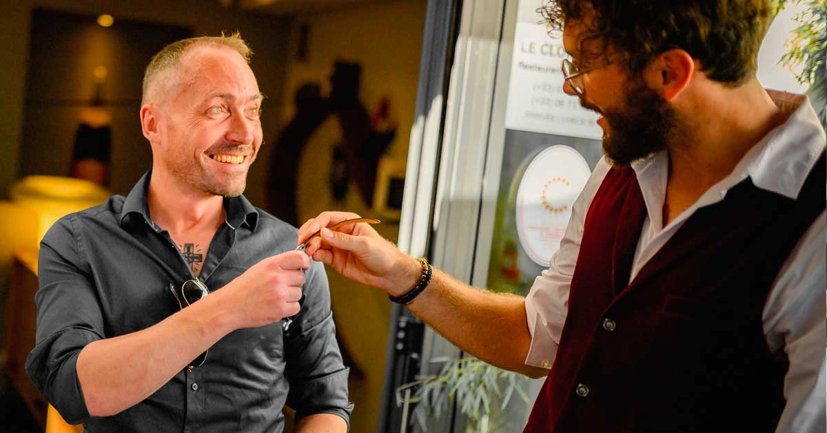 Le magicien professionnel Sebastien Pieta fait un tour de magie à des spectateurs surpris dans un événement d'entreprise en région Grand-Est